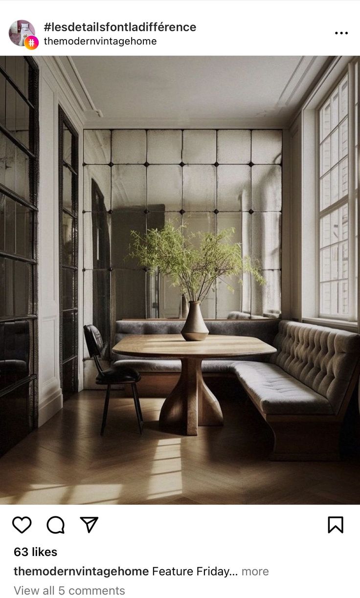 a table with a vase on top of it in front of a couch and window