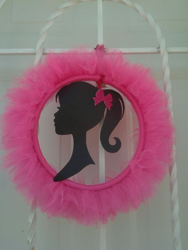 a pink wreath with a silhouette of a woman