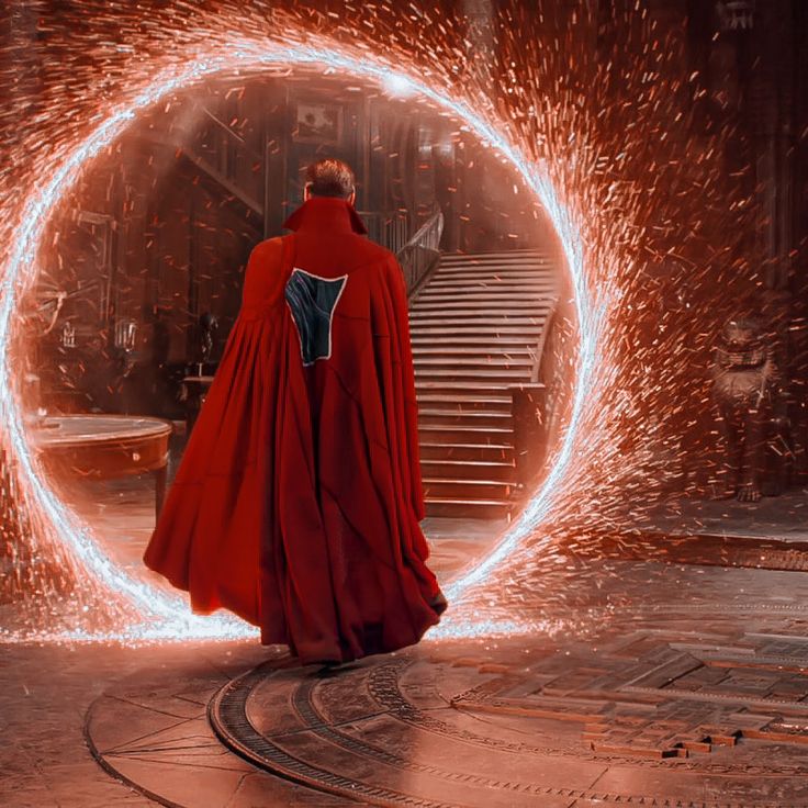 a man in a red cape and cloak is walking through a tunnel with sparks coming out of it