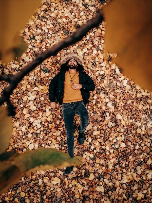 a man laying on top of a pile of leaves