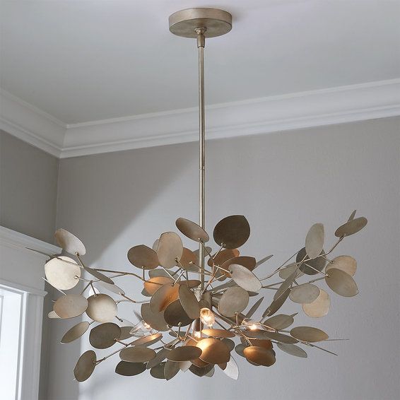 a chandelier with leaves hanging from it's ceiling in a living room