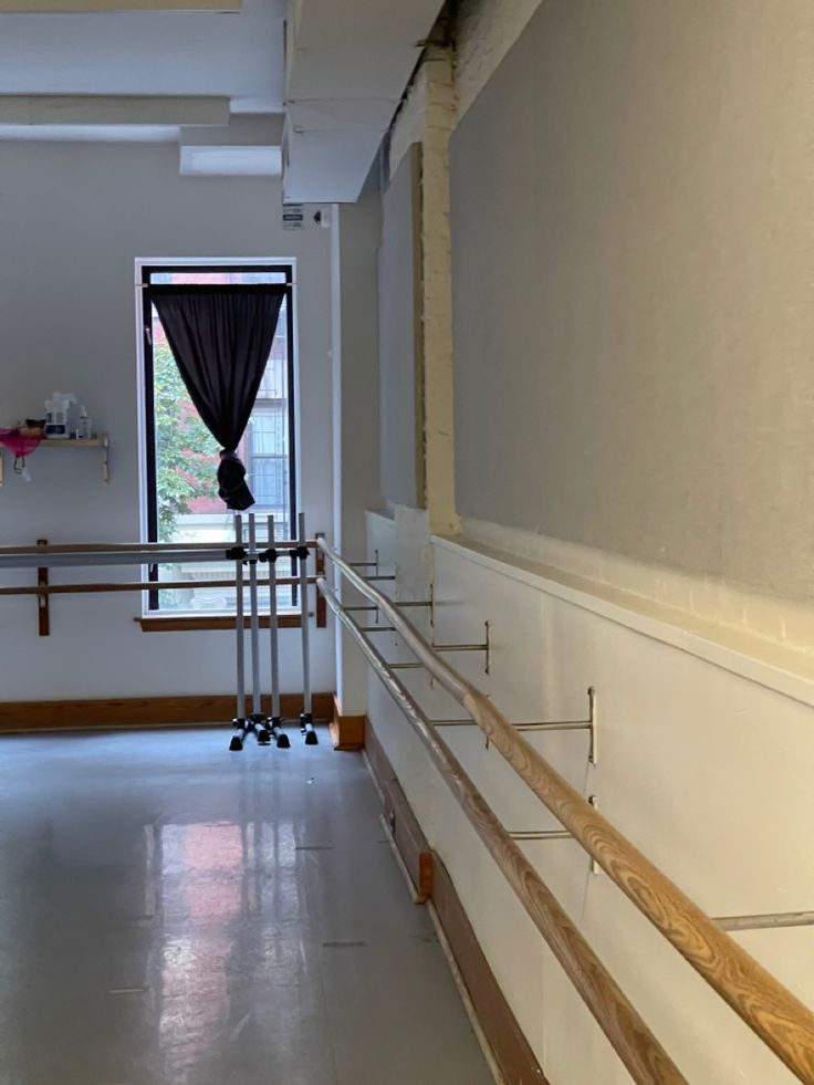 an empty hallway with railings and windows