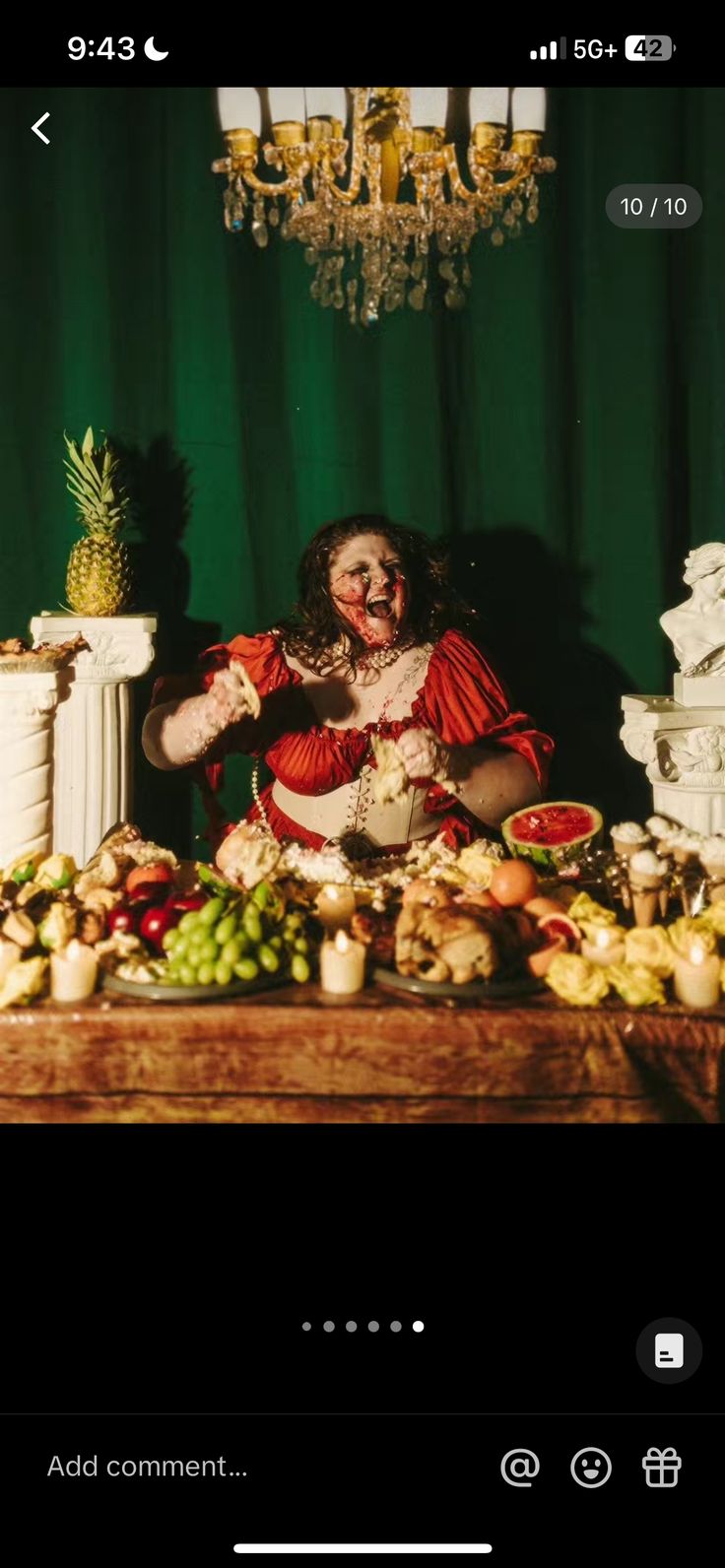 a creepy clown sitting in front of a table full of food