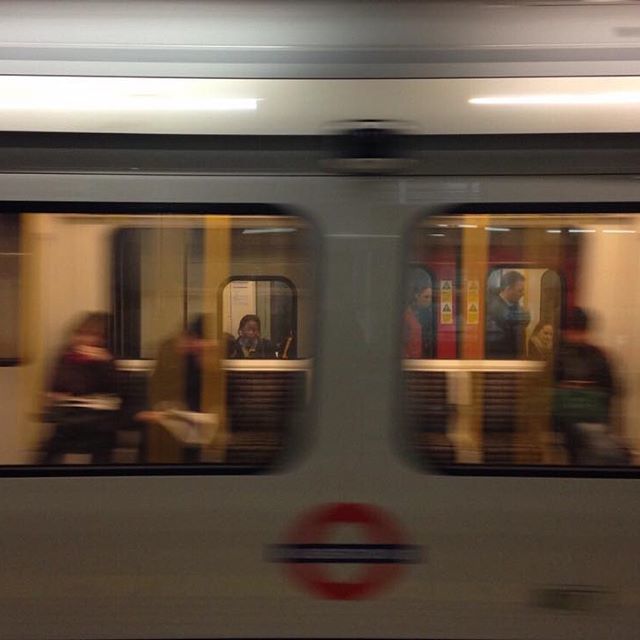 people are sitting on the subway train as it's moving through the city at night