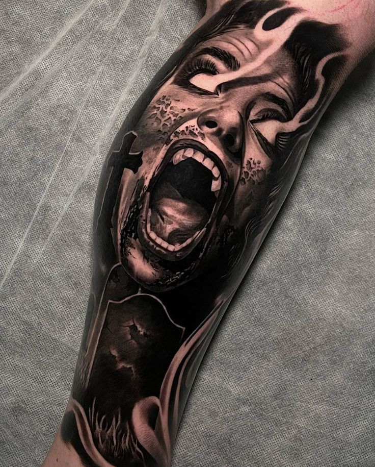 a man's leg with a tattoo on it and an image of a woman screaming