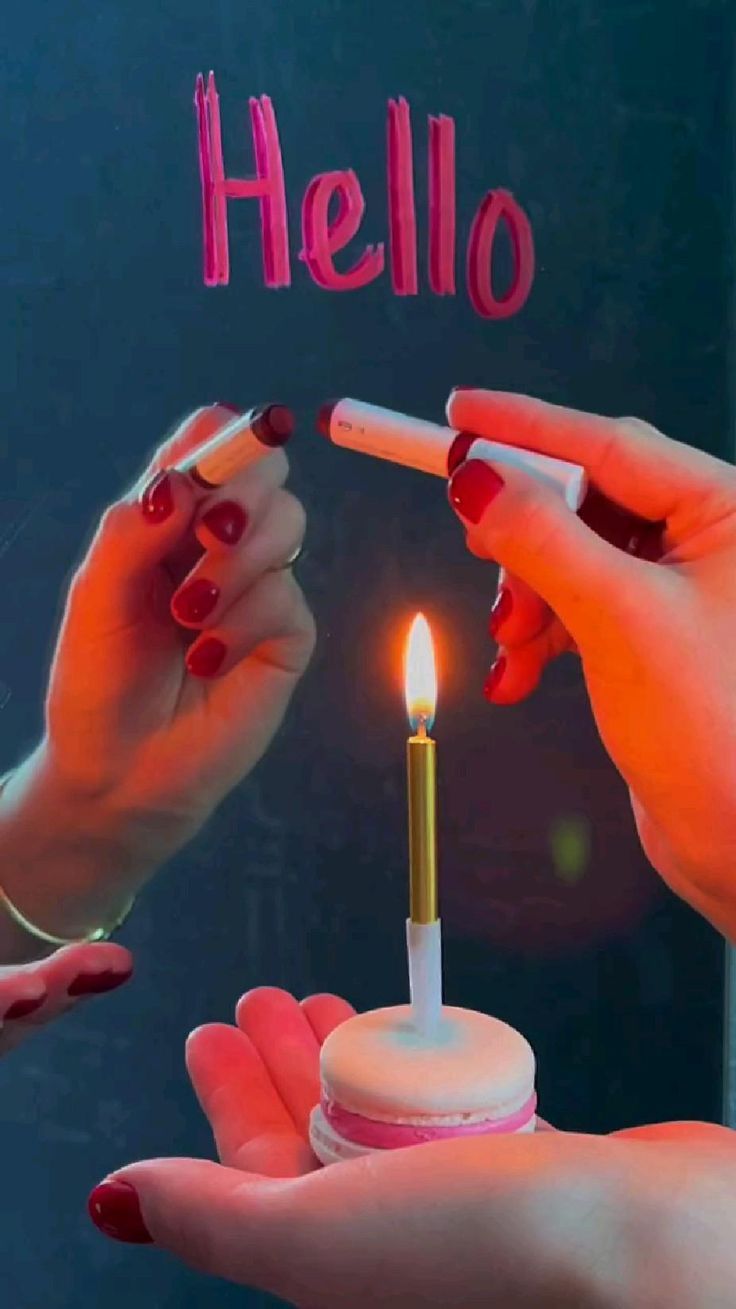 two women holding candles in their hands with the word hello written on them and one woman lighting a candle