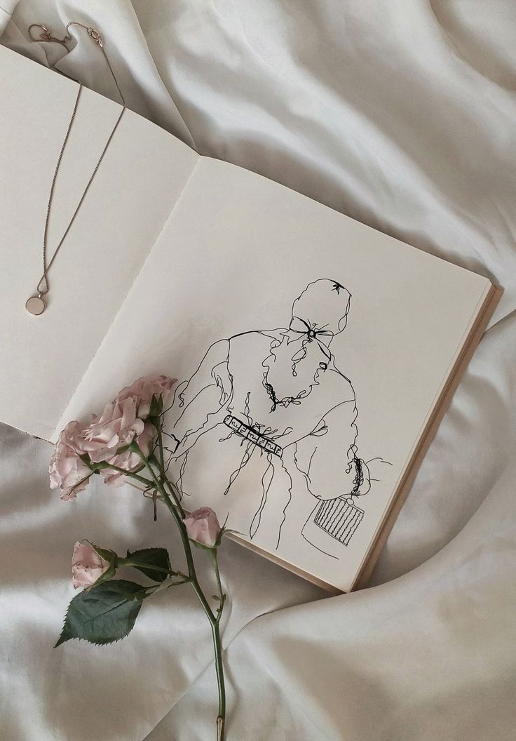 an open book with a drawing of a gorilla on it next to a pink flower