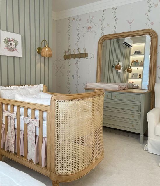 a baby's room with a crib, dresser and mirror