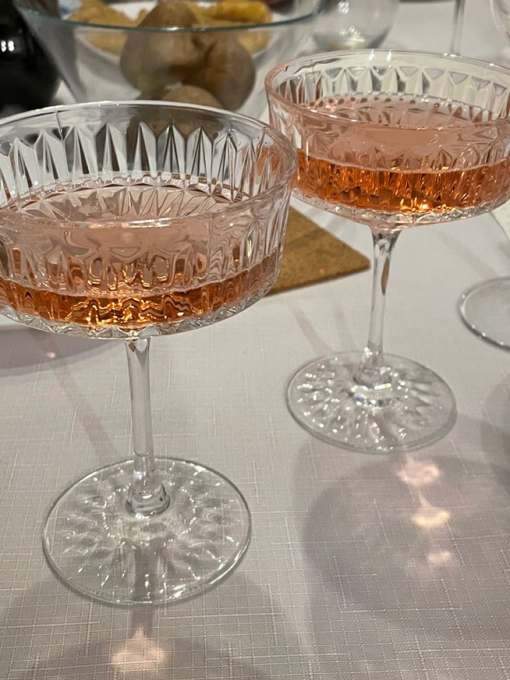 two wine glasses sitting on top of a table