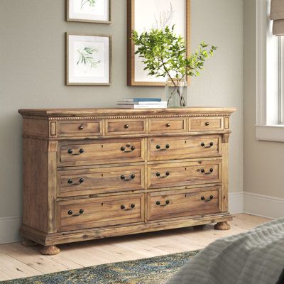 a bedroom with a dresser and pictures on the wall