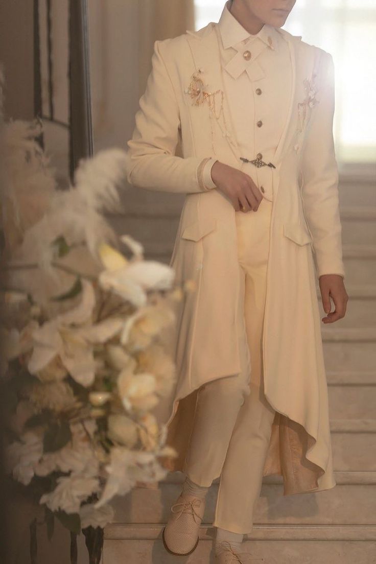 a man in a white suit and hat standing next to a vase with flowers on it