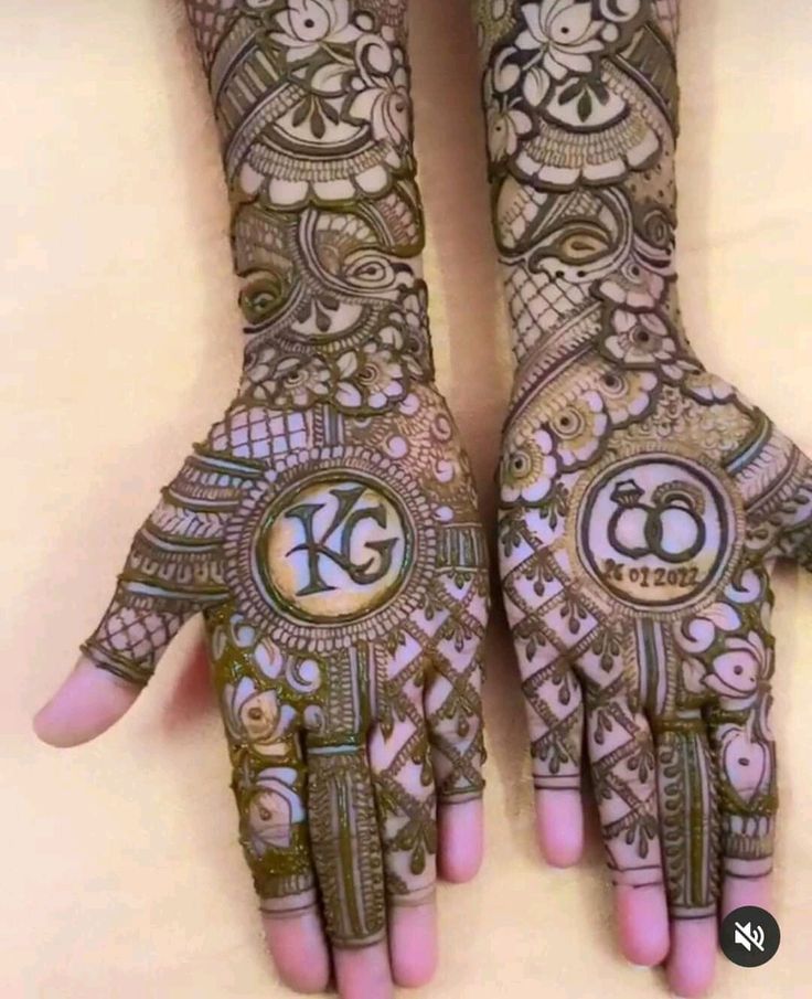 two hands that are decorated with henna and designs on them, one has the letter k