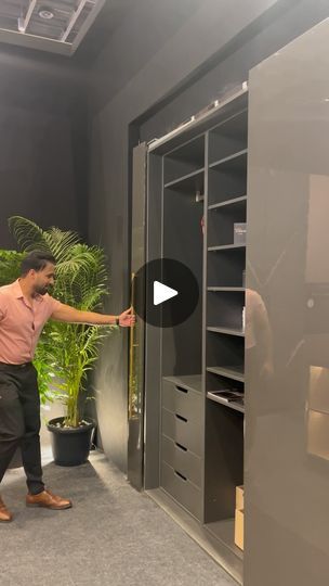 a man standing in front of an open closet next to a potted palm tree