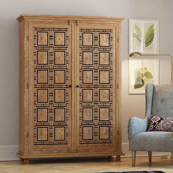 a room with a chair, armoire and rug on the floor in front of it