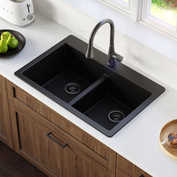 two black sinks sitting on top of a white counter