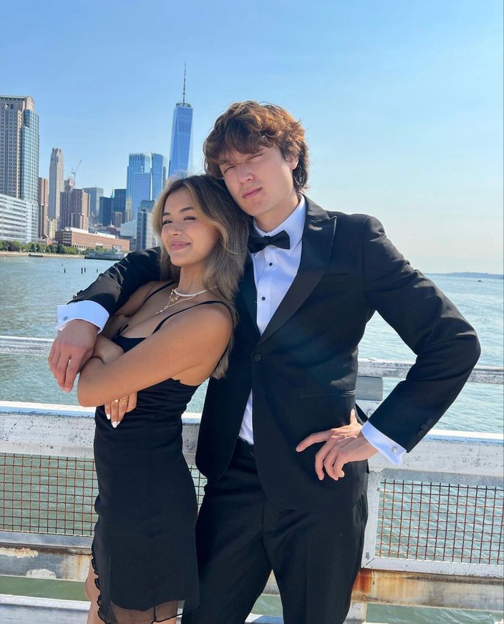 a man in a tuxedo standing next to a woman wearing a black dress