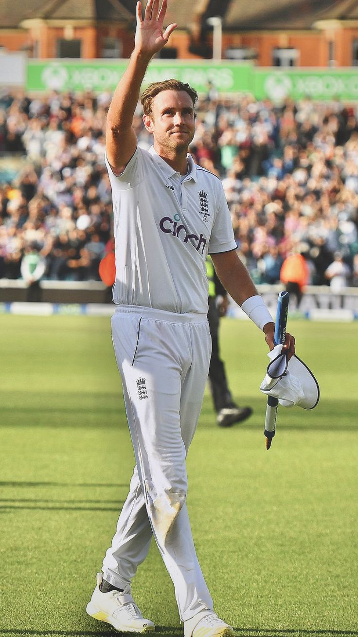 a cricket player waves to the crowd as he walks off