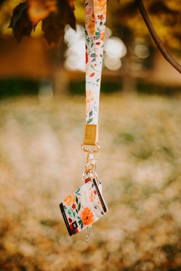 an orange and white flowered lanyard hanging from a tree