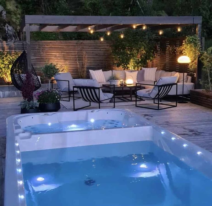 a hot tub sitting on top of a wooden deck next to a table and chairs