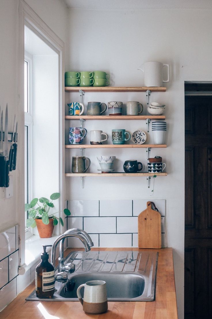 a kitchen with wooden counters and shelves filled with dishes on top of the countertop