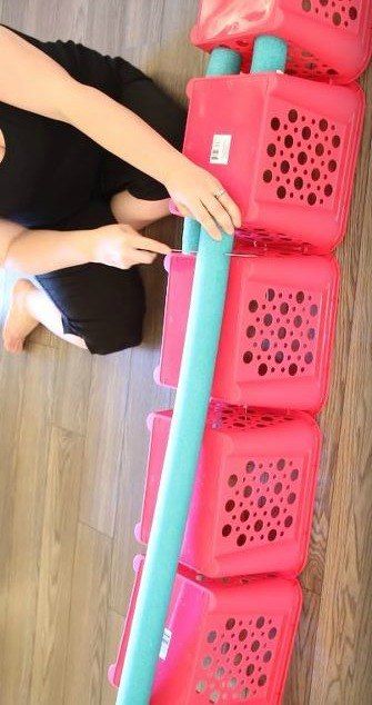 a woman is sitting on the floor next to several plastic containers with holes in them