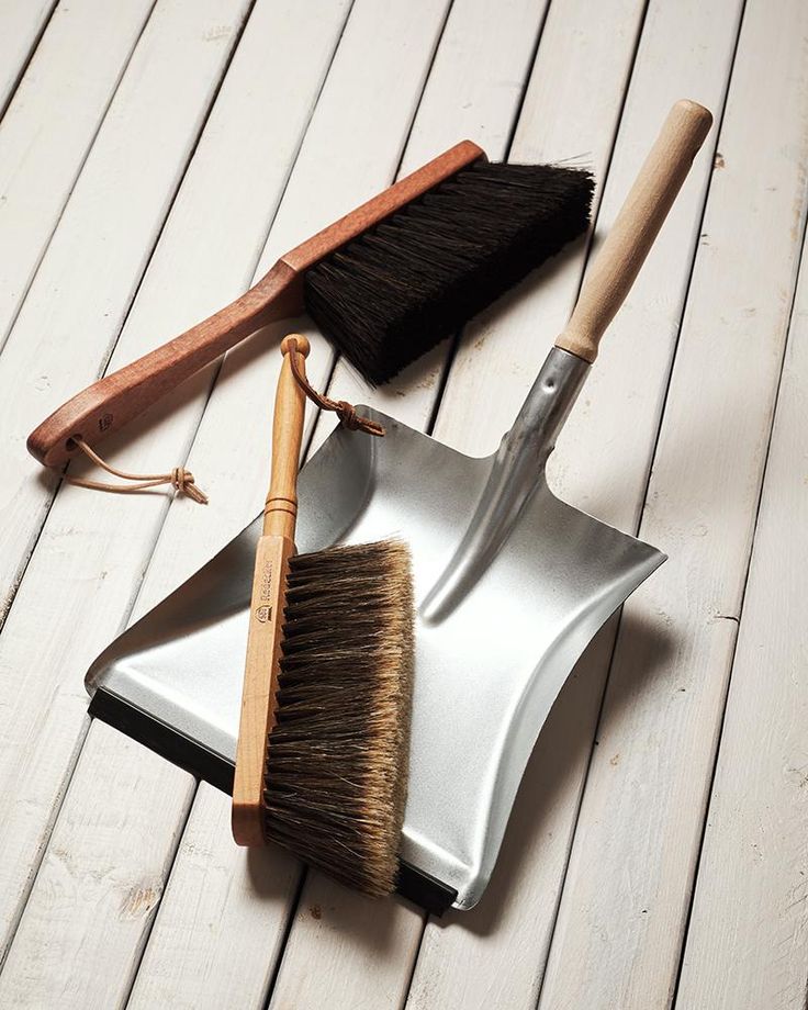 there are two brushes and a brush on the floor next to each other, one with a wooden handle