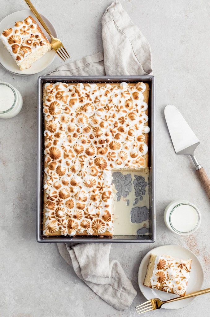 a pan filled with cake sitting on top of a table next to plates and utensils