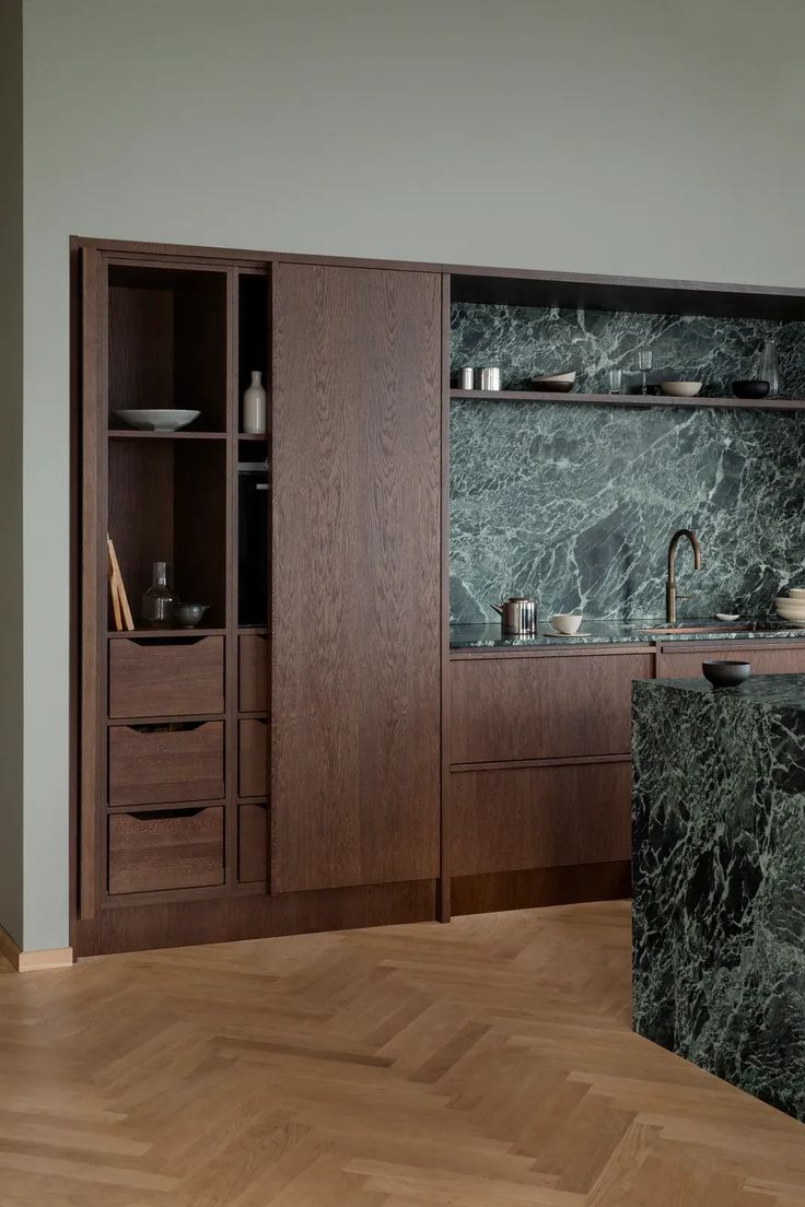 a kitchen with wooden cabinets and marble counter tops