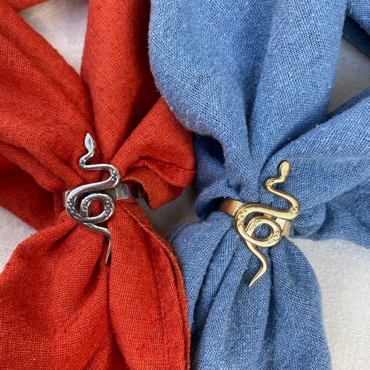 two pieces of cloth tied together with metal clasps on top of each other, one red and the other blue