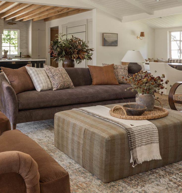 a living room filled with furniture and a large rug on top of a carpeted floor