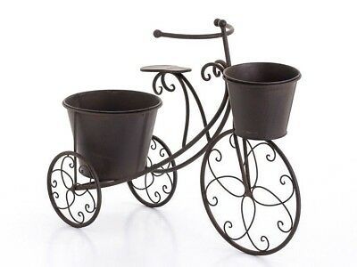 a metal bicycle with two flower pots on the front and back wheels, is shown