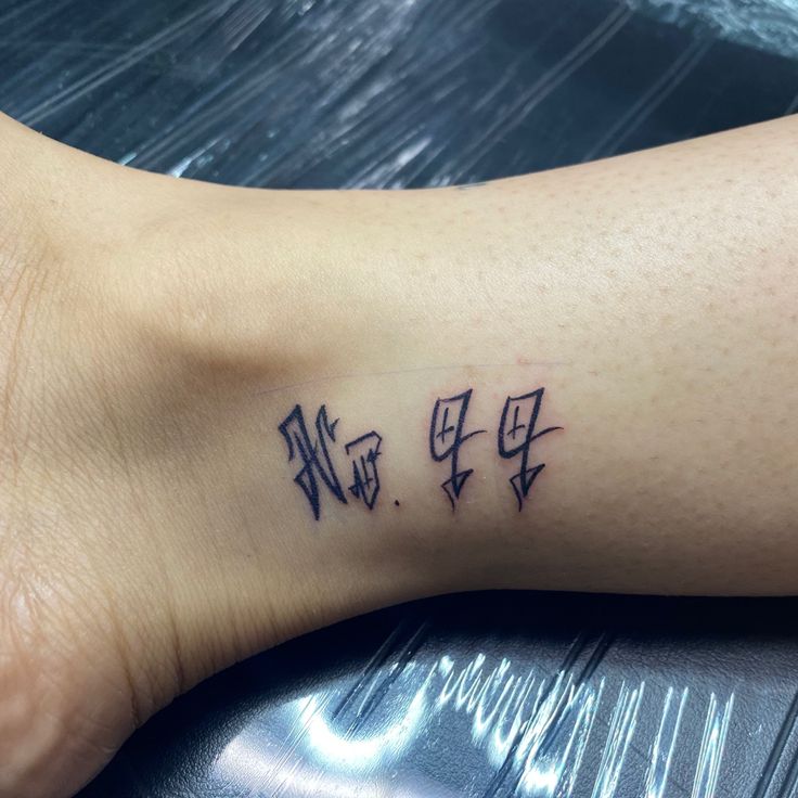 a person with a tattoo on their foot that has chinese characters tattooed on the side