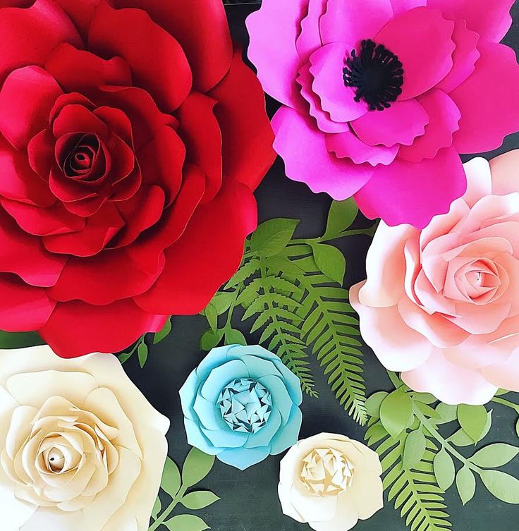 paper flowers are arranged on a black surface