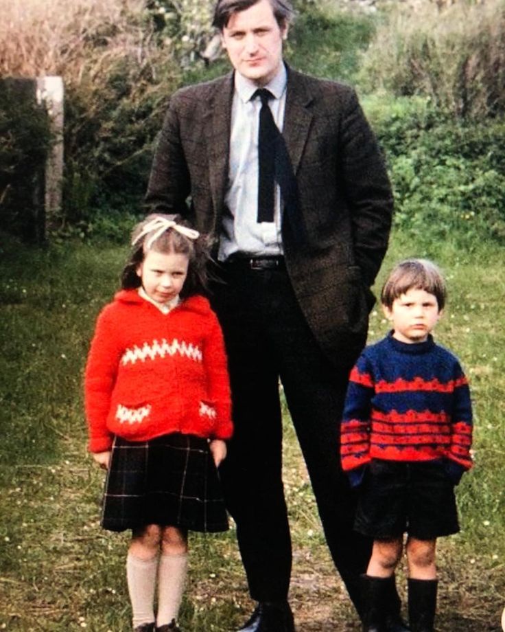 a man standing next to two small children