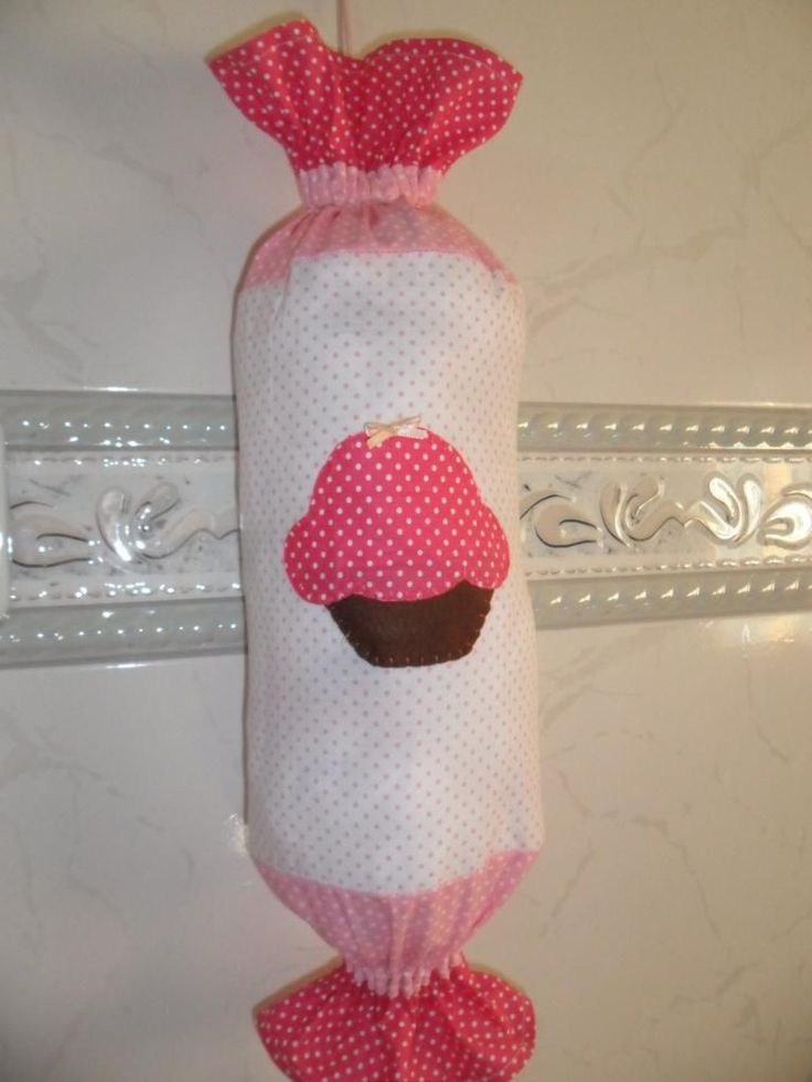 a pink and white bag with a cupcake on it hanging from the side of a door