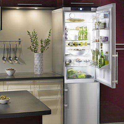 an open refrigerator in a kitchen with the door ajar and shelves full of food