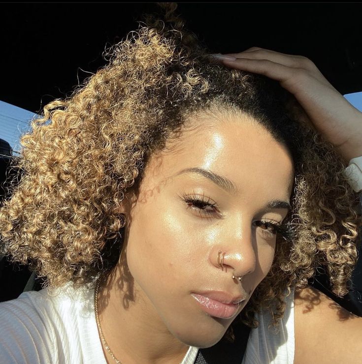 a close up of a person in a car with her hand on her head,