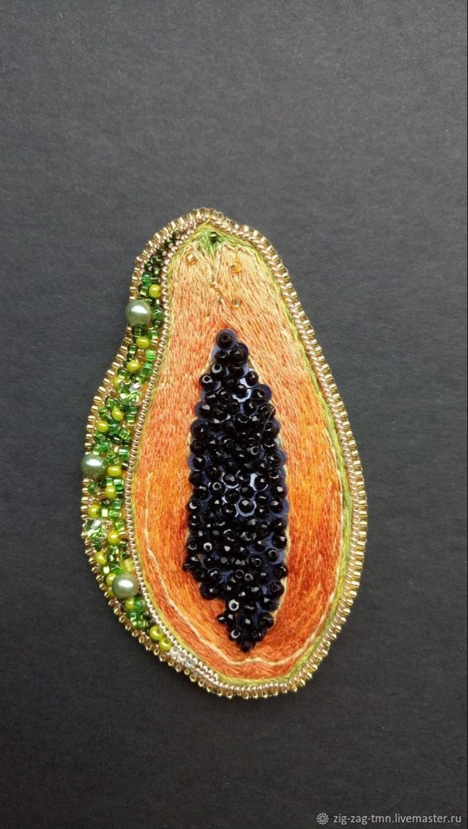 a brooch with beads and bead work in the shape of an eggplant