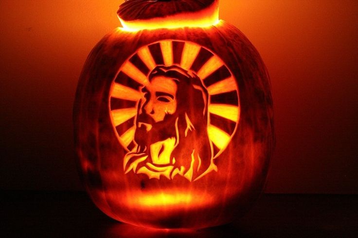 a carved pumpkin with the image of jesus on it