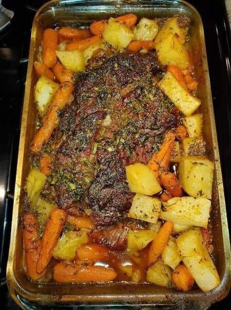 a casserole dish with carrots, potatoes and meat