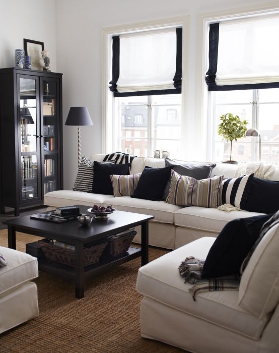 a living room filled with furniture and a book shelf in front of a large window