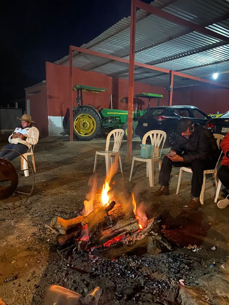 people sitting around a fire pit in the dirt