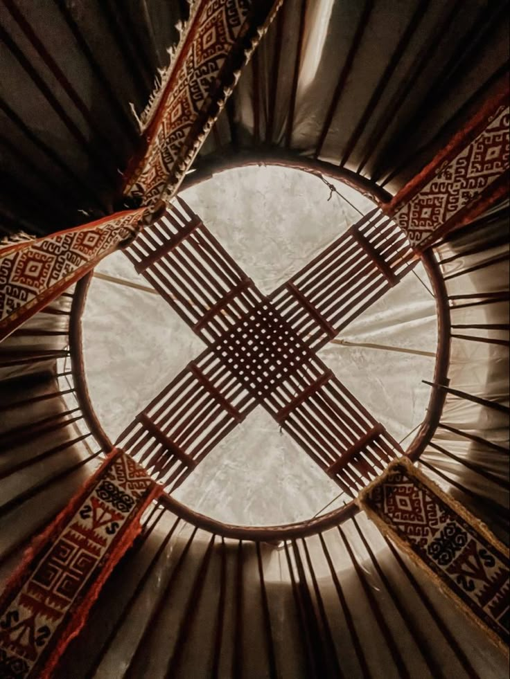 the inside of a yurt looking up at the ceiling and round hole in it