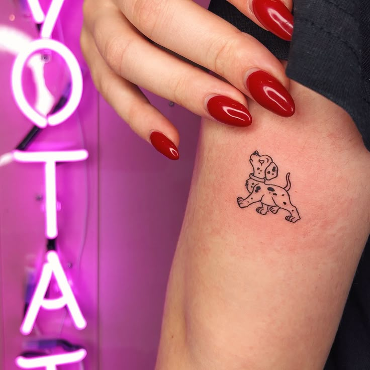 a woman's arm with a small dog tattoo on it