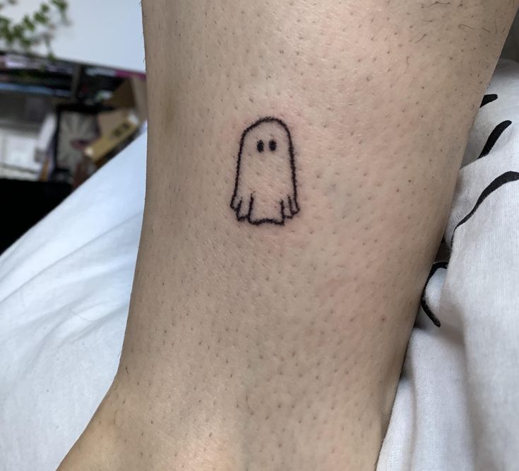 a small ghost tattoo on the ankle