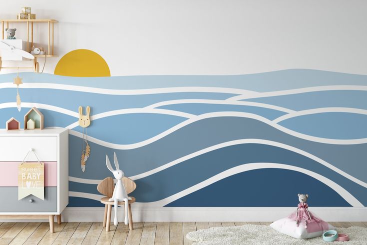 a child's room decorated in blue and white with waves painted on the wall