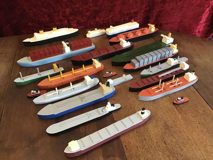 a group of toy boats sitting on top of a wooden table next to each other