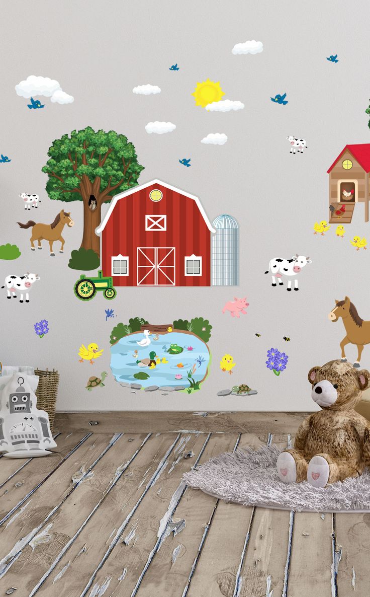 a teddy bear sitting on top of a rug in front of a wall with farm animals