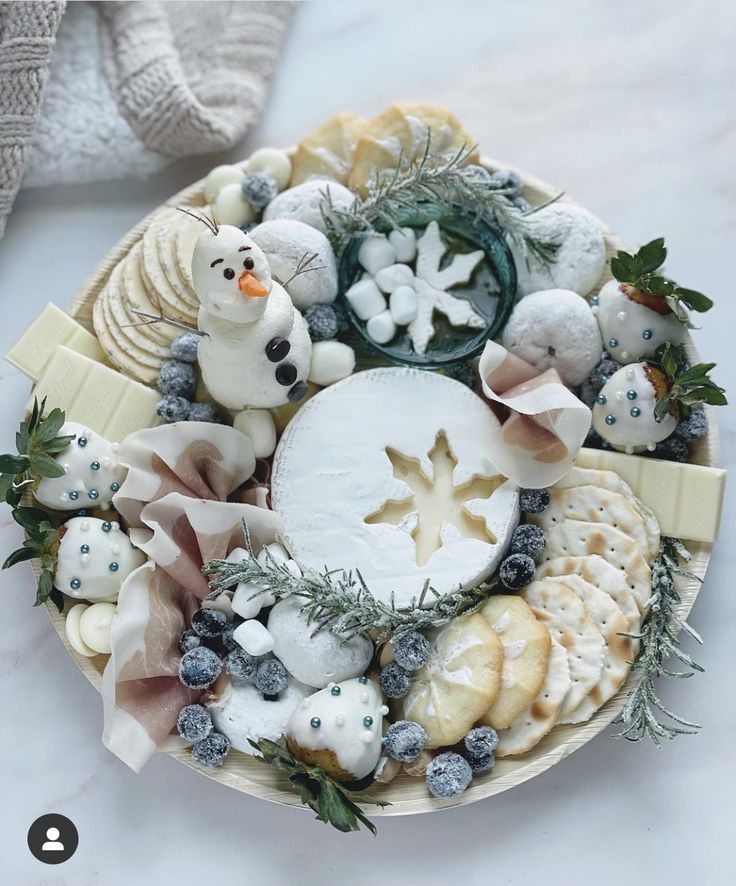 a platter filled with different types of cheeses and other foods on top of a table