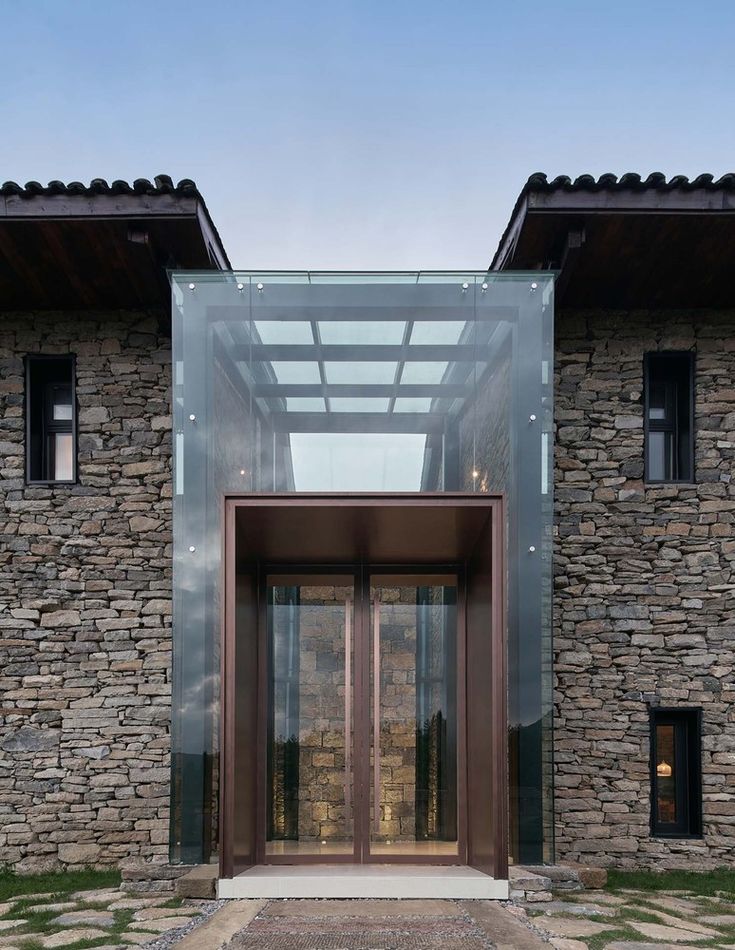 an entrance to a stone building with glass doors